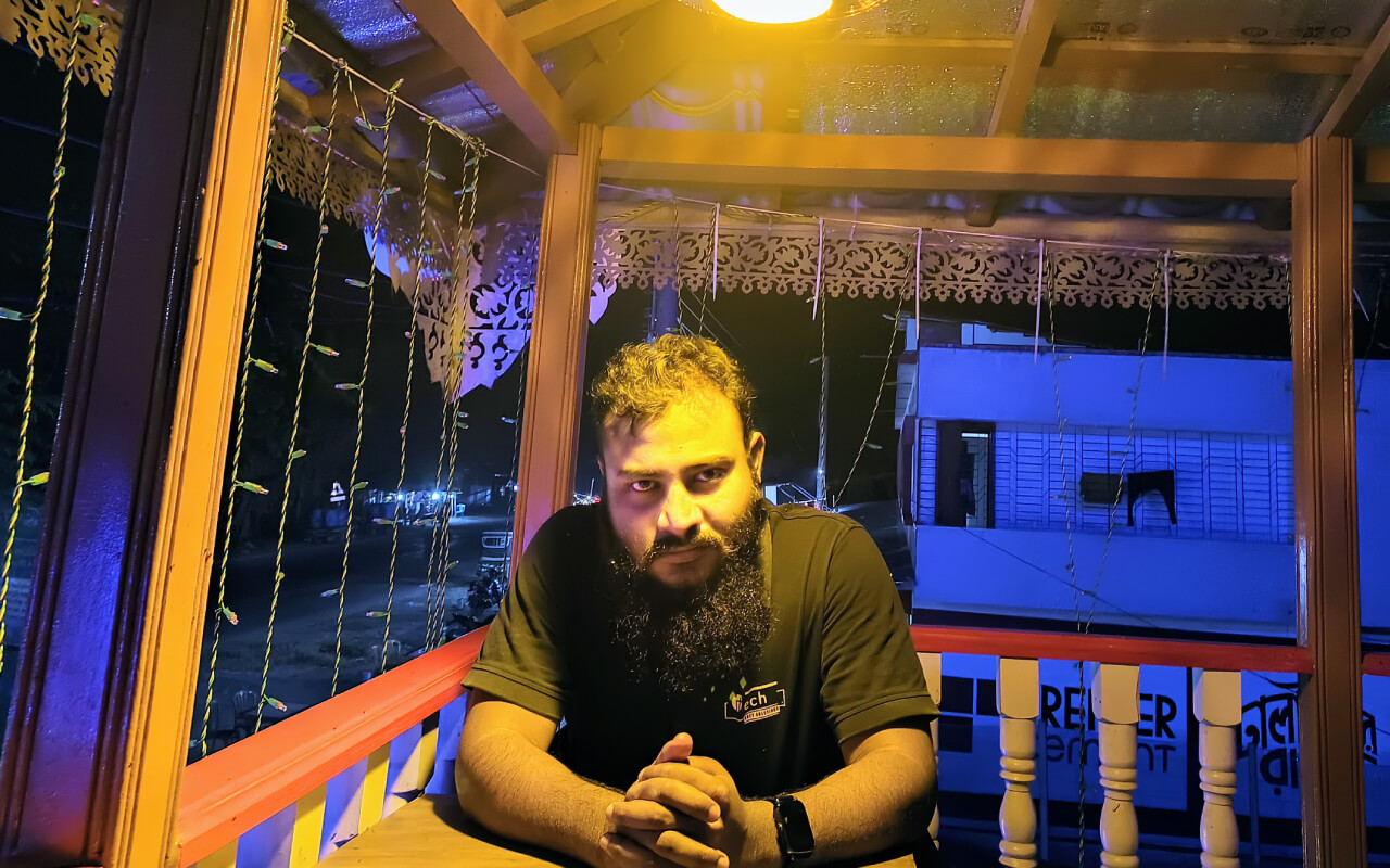 A person sitting at a desk in a countryside restaurent down to a warm light